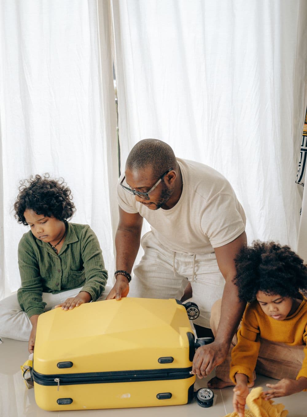 A father and his children packing a suitcase together